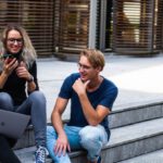 Universities - Three Persons Sitting on the Stairs Talking With Each Other