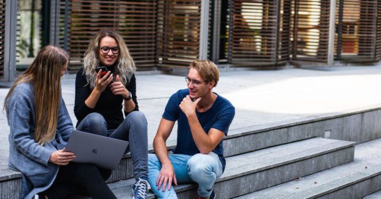 Universities - Three Persons Sitting on the Stairs Talking With Each Other