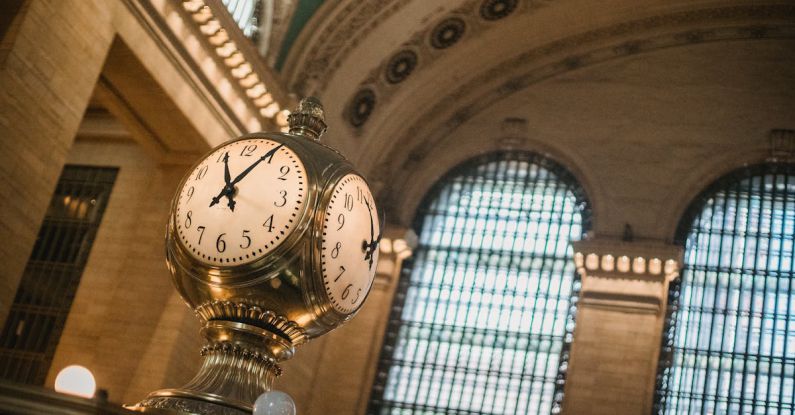 Heritage Railways - From below of vintage golden clock placed in hallway with aged interior with ornamental walls and windows and high ceilings placed in Grand Central Terminal in New Your City in daytime