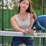 Tennis Clubs - A woman posing for a photo on a tennis court