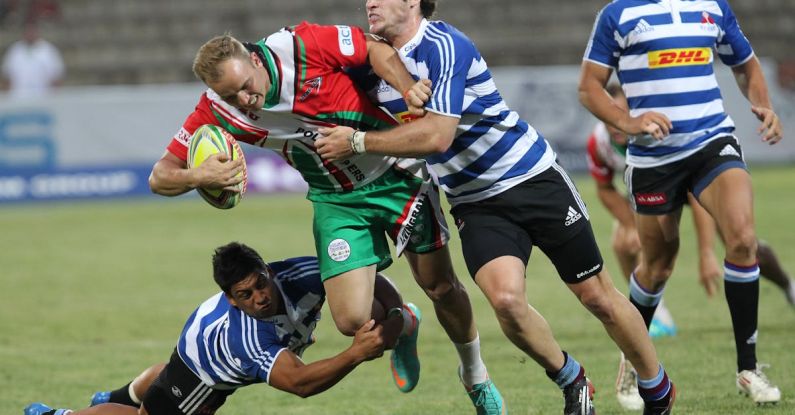 Rugby Stadiums - Man in Blue and White Striped Soccer Jersey Playing Rugby