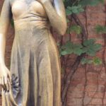 Shakespeare - Metal Statue of Juliet by a Brick Wall with a Creeper Plant