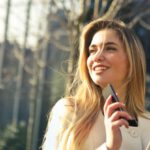 Fashion Schools - Woman Wearing White Top Holding Smartphone and Tablet