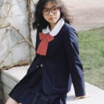 Student Visa - A girl in a school uniform sitting on a bench