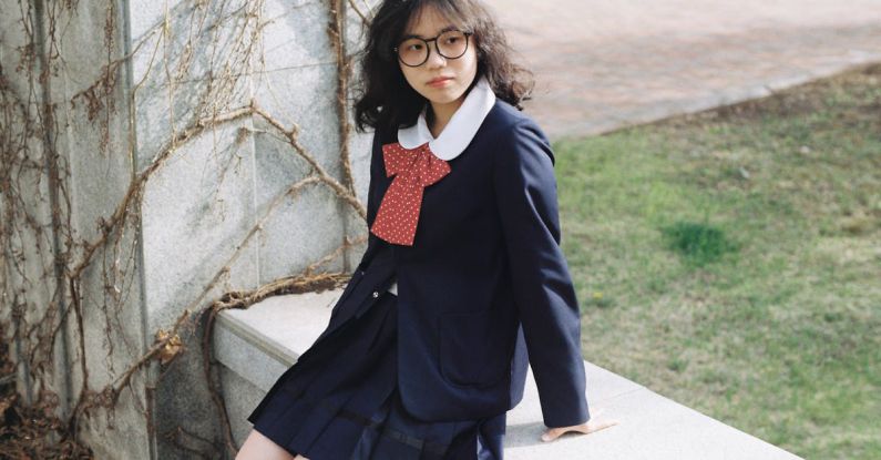 Student Visa - A girl in a school uniform sitting on a bench