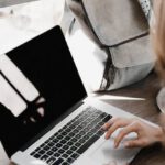 Work And Study - Close-up Photography of Woman Sitting Beside Table While Using Macbook