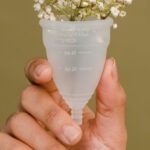 Tudor Period - Faceless woman showing menstrual cup with tender white flowers