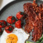 English Breakfast - Bacon and Egg with Tomatoes and Sliced Avocado on Ceramic Plate