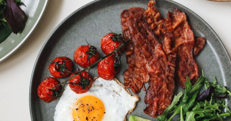 English Breakfast - Bacon and Egg with Tomatoes and Sliced Avocado on Ceramic Plate