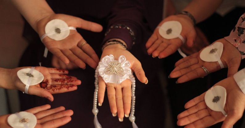 British Bands - A group of hands holding white flowers and a white ring