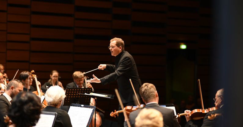 Classical Concert - Orchestra and Conductor During the Performance