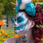 Notting Hill Carnival - Portrait of a Woman in a Blue Traditional Mask and Orange Flowers